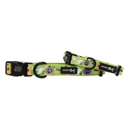 The Sassy Woof Dog Collar - Haunt Mess is a green adjustable collar with a Halloween pumpkin and skull pattern, black plastic buckles, sturdy D-ring, soft neoprene, and a black label featuring the brand name.