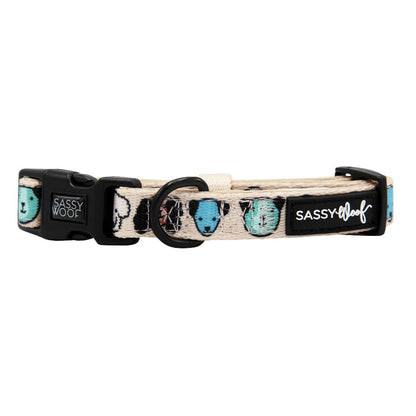 The Dog Collar - Mixed With Love by Sassy Woof is a beige, adjustable neoprene collar with blue and black spots, a sturdy D-ring for leash attachment, a black buckle, and the Sassy Woof logo.