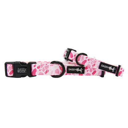 The Sassy Woof Dog Collar - Mykonos features pink neoprene and black buckles, offering adjustable comfort and style—perfect for pups looking for a chic Mykonos-inspired accessory.