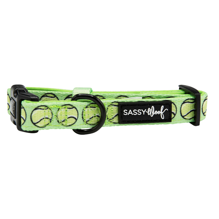 The Dog Collar - Serving Up Sass by Sassy Woof is a green adjustable dog collar with black hardware, decorated with tennis balls and finished with a black Sassy Woof label in white text.
