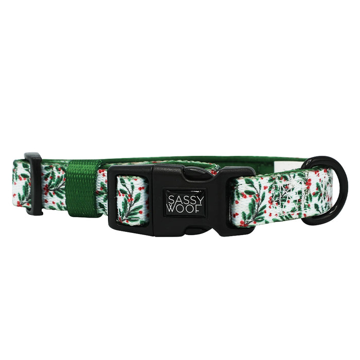 The Dog Collar - Under the Mistletoe by Sassy Woof features a green and white holly pattern, adjustable green strap, and black Sassy Woof buckle—perfect for pairing with matching dog accessories.