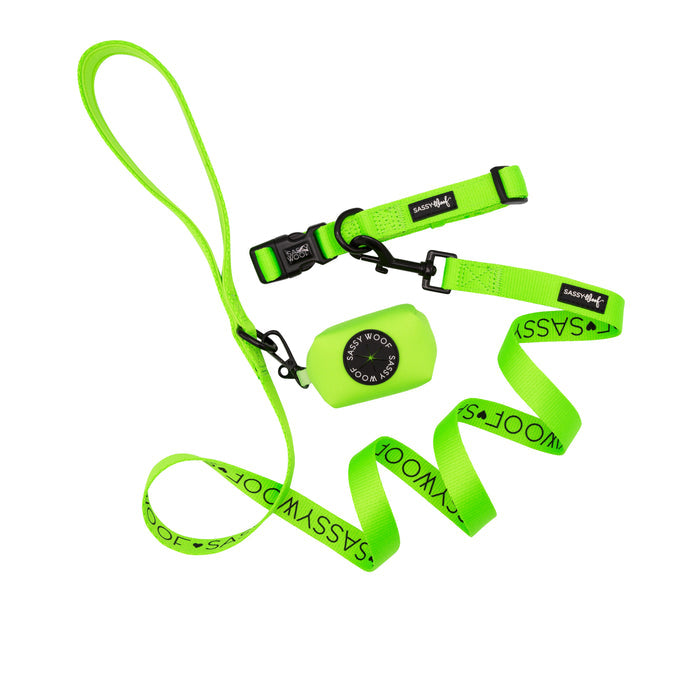 The Sassy Woof Dog Collar Three Piece Bundle in Neon Green, featuring a matching neon dog collar, leash, and waste bag holder, is arranged on a white background—an eye-catching set of neon dog accessories.