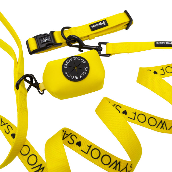 The Sassy Woof Dog Collar Three Piece Bundle in neon yellow features a matching dog collar, leash, and waste bag dispenser attached to the leash, all shown on a white background.