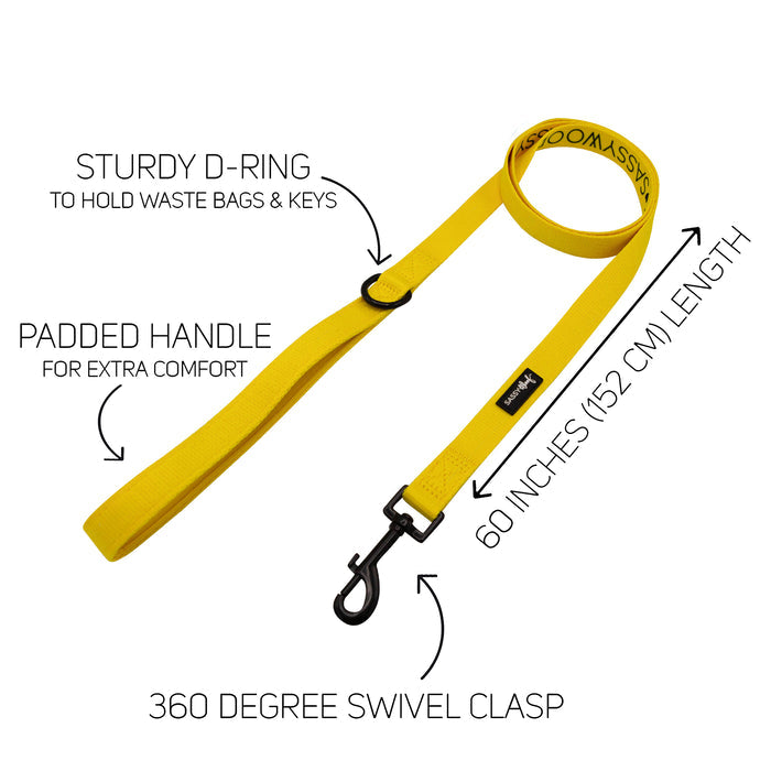 Introducing the Sassy Woof Dog Collar Three Piece Bundle in Neon Yellow: This bundle features a neon yellow dog leash with a padded handle for added comfort, a sturdy D-ring for attaching waste bags, and a 360-degree swivel clasp to prevent tangling. The leash measures 60 inches (152 cm) long and coordinates perfectly with other neon yellow accessories. Text labels highlight each key feature.