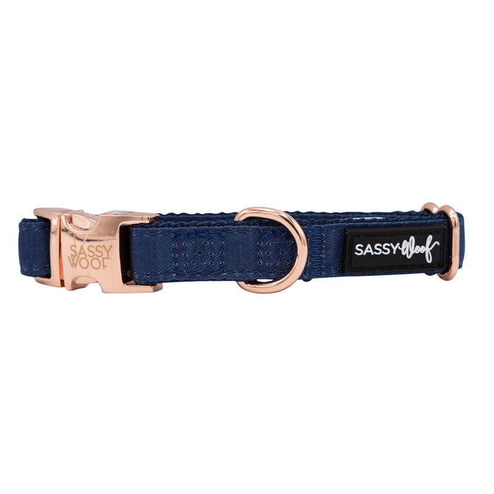 The Sassy Woof Dog Four Piece Bundle - Twilight features a navy blue collar with rose gold hardware, including a buckle and D-ring, and a black patch label reading “SASSY WOOF” in white.