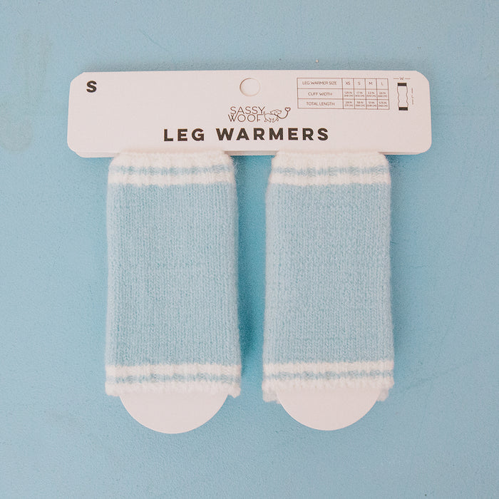 A pair of small, blue and white striped Dog Leg Warmers - Blue by Sassy Woof are shown attached to branded packaging on a light blue background. These cold weather accessories for dogs come in size S.