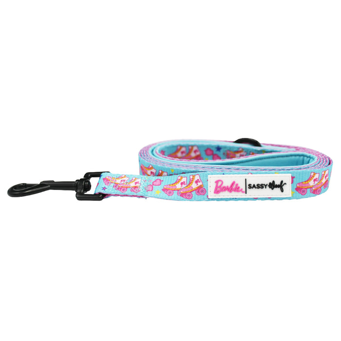 The Dog Two Piece Bundle - BARBIE™ On a Roll by Sassy Woof is a colorful leash with roller skate patterns in pink, blue, and yellow. It features a black metal clip and a label showing both brand logos on a white background.
