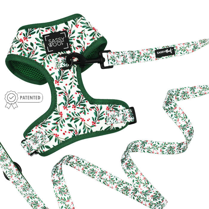 The Sassy Woof "Dog Two Piece Bundle - Under the Mistletoe" features a festive, adjustable harness and leash with green trim, white background, and red berries—perfect for your growing pup’s holiday adventures!.