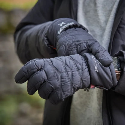 Person wearing a pair of black Extremities Paradox lightweight waterproof gloves on a blurred natural background