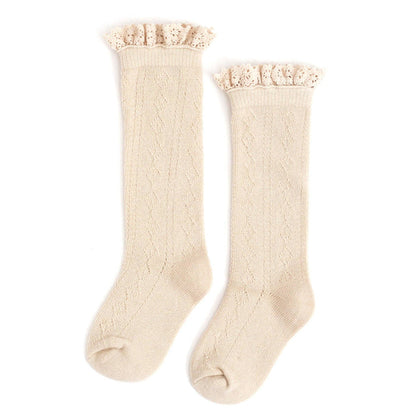 A pair of Fancy Lace-Top Knee-High Socks in Vanilla by Little Stocking Co., featuring delicate knit patterns and ruffled lace trim at the top, laid flat side by side on a white background—perfect knee-high socks with a vintage-inspired flair.
