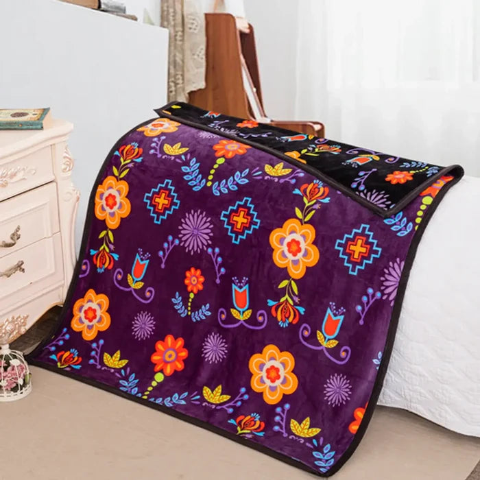 Floral Mink Baby Blanket displayed on a bed, featuring colorful floral patterns on a soft purple background.