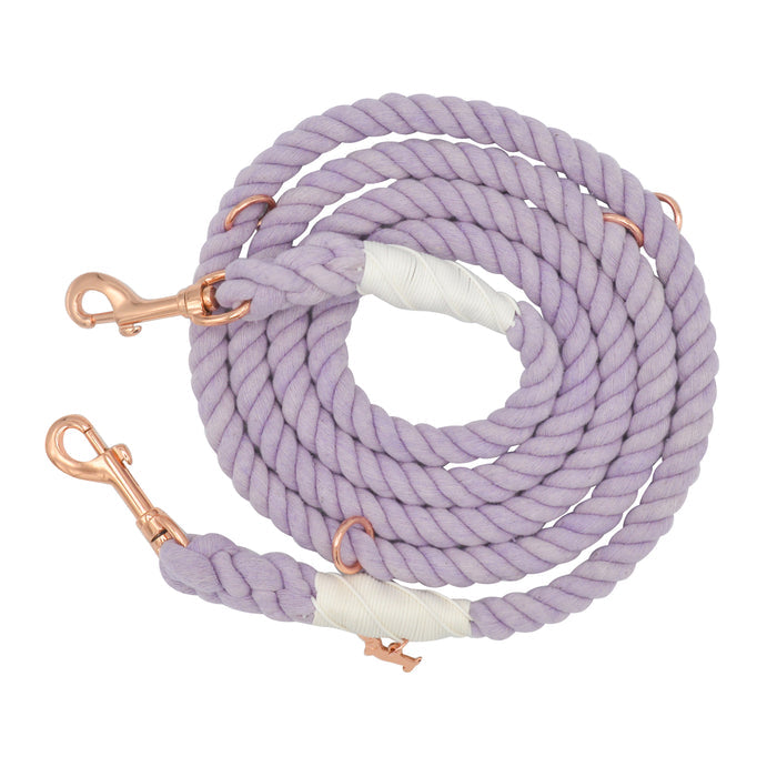 The Sassy Woof Hands-Free Rope Leash - Lavender is a stylish and functional dog leash, hand-crafted with a coiled lavender rope, white binding at the ends, and two rose gold metal clips.