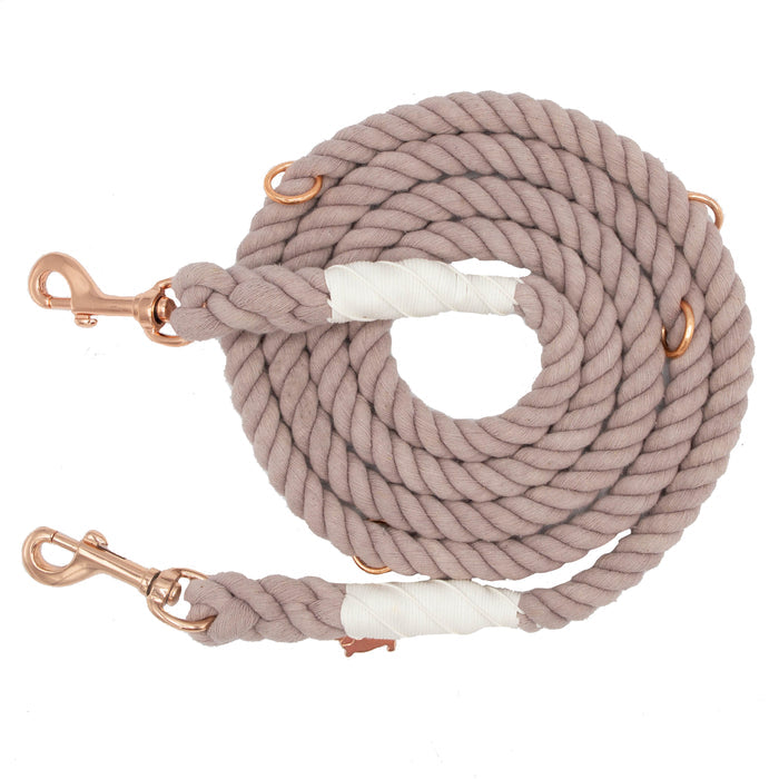 A light brown, coiled Hands-Free Rope Leash - Le Café from Sassy Woof, featuring rose gold metal clips at both ends and white tape-wrapped reinforcements.