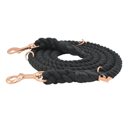 The Hands-Free Rope Leash - Noir by Sassy Woof features a coiled black braided design with rose gold metal clips at each end, displayed against a white background. This hand-crafted leash is stylish and durable, making it perfect for daily walks.