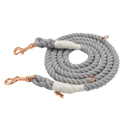 Introducing the Sassy Woof Hands-Free Rope Leash - Serenity: a hand-crafted, coiled light gray rope leash featuring rose gold metal clips at both ends and stylish white wrapped accents near the clips—blending durability with elegance for your daily walks.