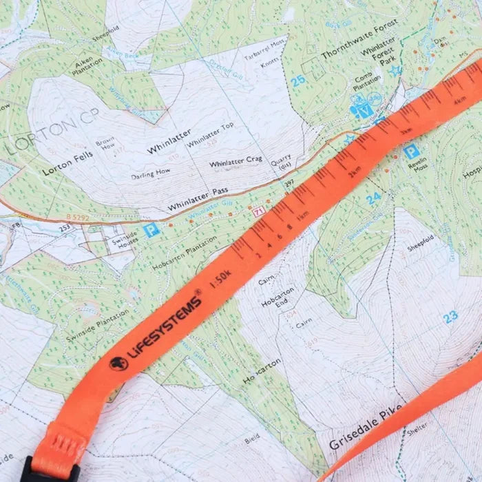 Lifesystems Hiking Compass lanyard shown on a topographic map showing its scales