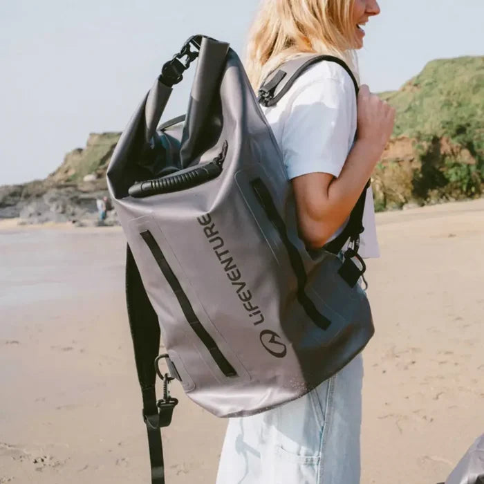 Person carrying a Lifeventure Heavy Duty Dry Bag Backpack 35L on their shoulder at the beach