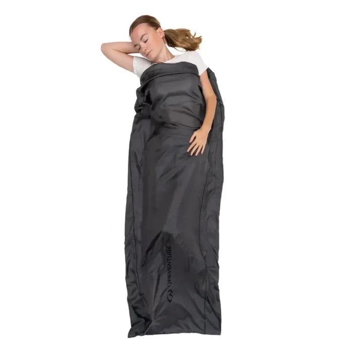 Person sleeping inside a Lifeventure silk blend mummy shape sleeping bag liner on a white background