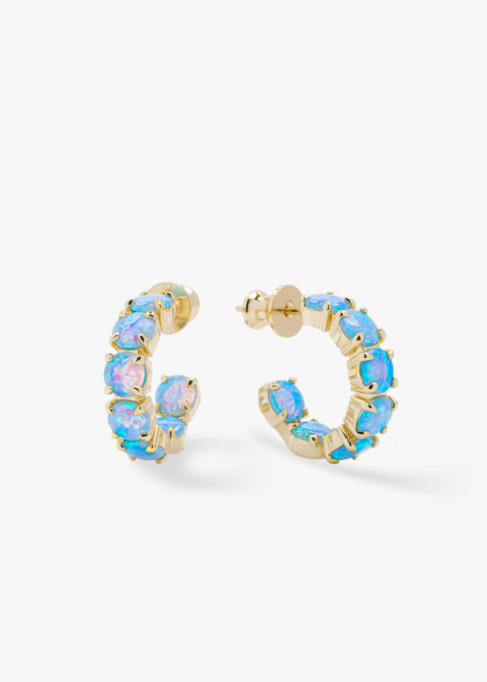 Blue opal hoops with gold framing against a white background