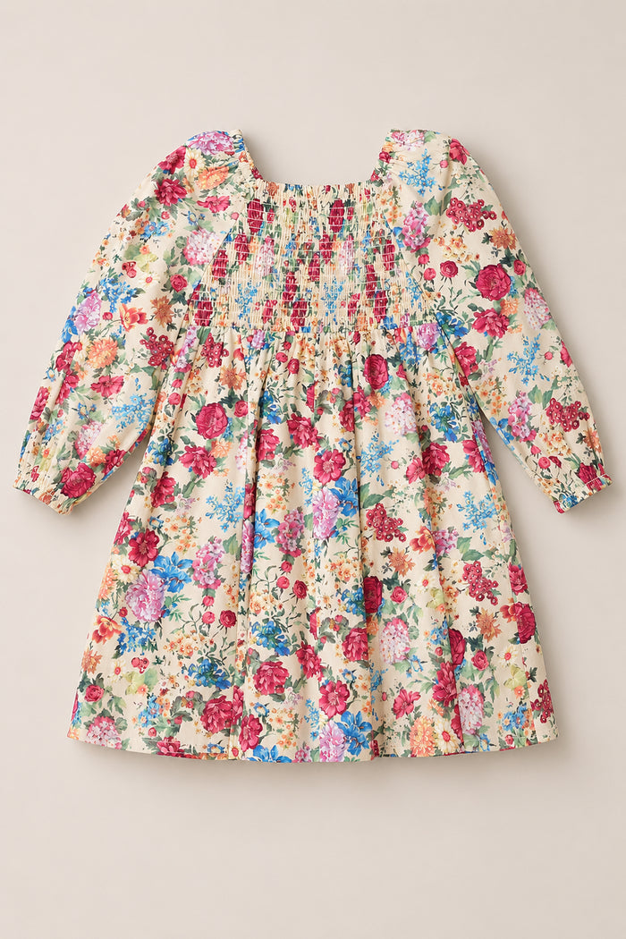 The Mini Adelpha Dress in Autumn Amity Floral by Ivy City Co features long balloon sleeves, a smocked bodice, and a gathered knee-length skirt. Showcasing a vibrant floral print on a cream background, this dress combines playful charm with sophisticated style.