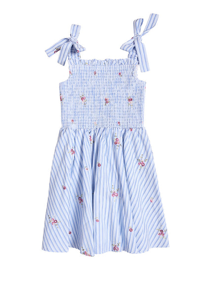 Ivy City Co Mini Bluebell Dress in blue & white stripes features small pink floral prints, a smocked bodice, and bow tie shoulder straps.
