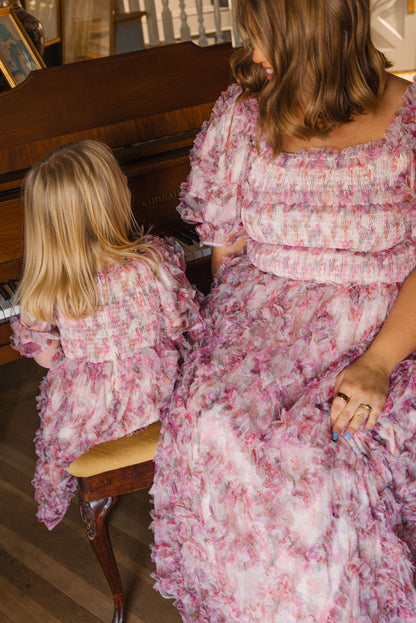 A woman and a young girl, both in Ivy City Co’s Mini Florentina Dress in Alluring Floral, sit side by side at a piano. Their matching spring-ready looks capture a sweet, shared moment as they face away from the camera.