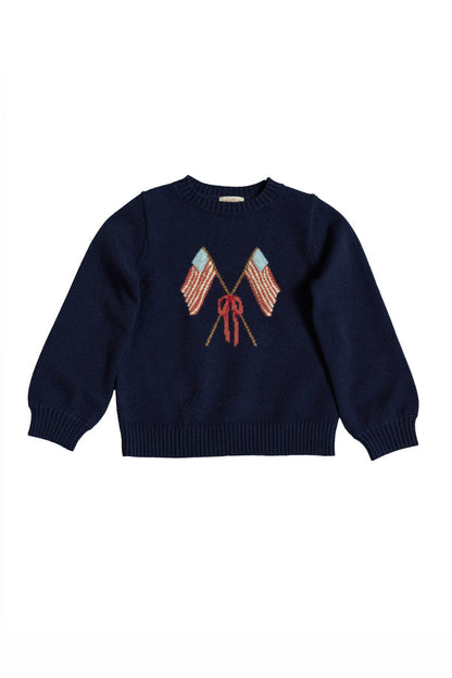 The Ivy City Co Mini Freedom Sweater in Midnight is a navy knit girls' sweater with two crossed American flags and a red bow, perfect for Fourth of July celebrations. Displayed on a white background.