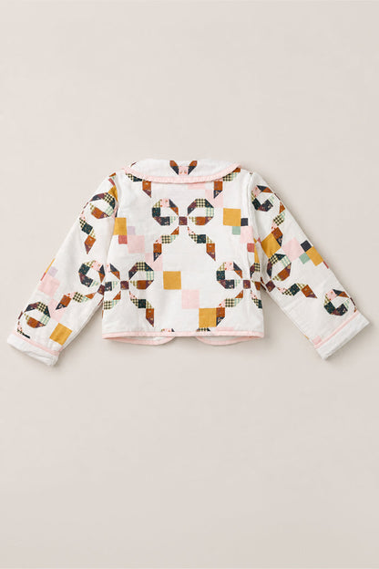Back view of the Mini Harper Jacket in Quilted Bow by Ivy City Co, a girls’ cotton jacket featuring a colorful patchwork quilt print with pink, mustard, navy, and green geometric patterns, finished with pink trim along the collar and hem.