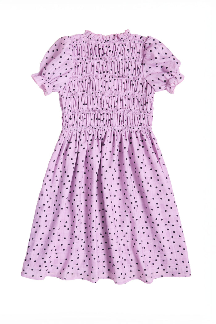 the back of a girls purple dress with black polka dots against a white background
