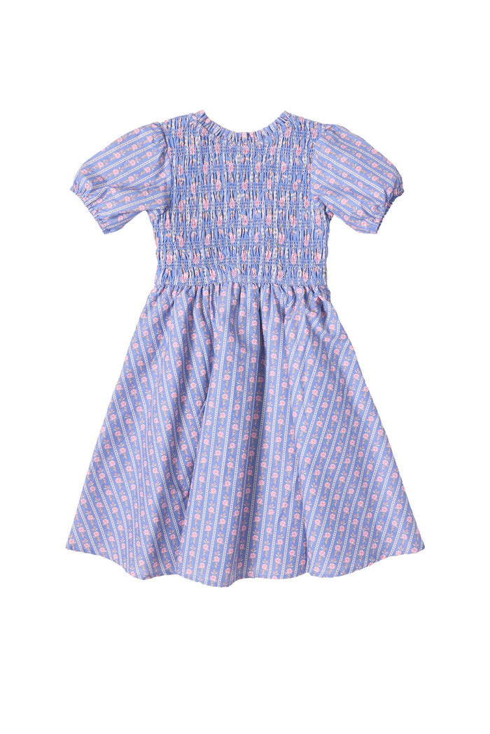 The Mini Mariah Dress in Linear Print by Ivy City Co is a girls’ midi dress in light purple linear floral cotton, featuring a smocked bodice, puffed sleeves, flared skirt, and pink and white florals for a sweet knee-length style.