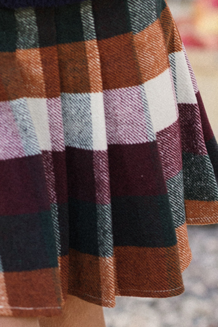 A close-up of the Mini Marren Skirt in Maize Brushed Gingham by Ivy City Co, a pleated wool-blend skirt featuring a plaid pattern in orange, dark green, burgundy, white, and purple. Expertly tailored pleats give it structure and style.