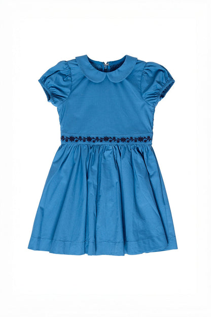 The Ivy City Co Mini Murphy Dress in Dark Teal is a charming girls’ short-sleeve dress featuring a Peter Pan collar, gathered waist, and delicate floral embroidery trim around the midsection. It boasts a full skirt and puffed sleeves, beautifully displayed against a white background.