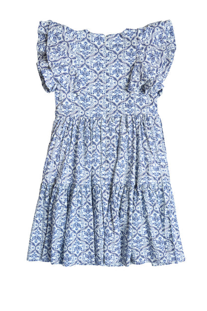 The Ivy City Co Mini Trixie Dress in Blue Moroccan Tile features a blue and white paisley pattern, ruffled neckline, and tiered skirt, shown laid flat on a white background.