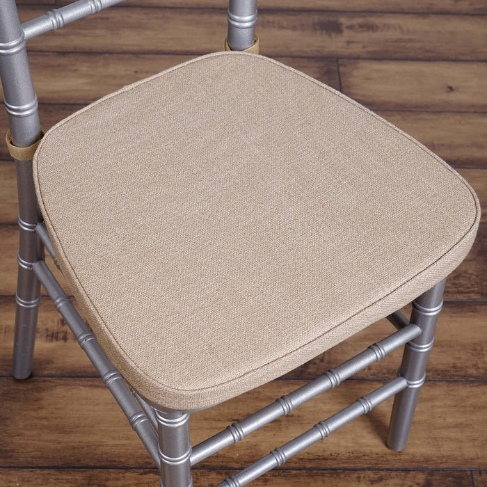 Beige upholstered chair seat with silver metal frame.
