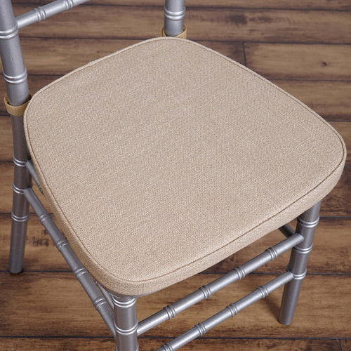 Beige upholstered chair seat with silver metal frame.
