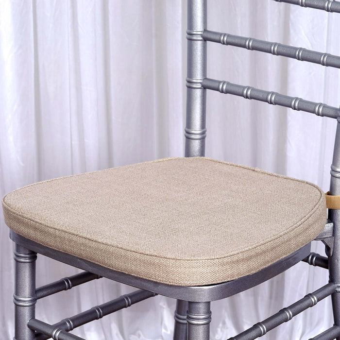 Silver chiavari chair with beige cushion on a plain background.