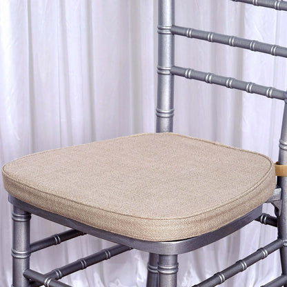 Silver chiavari chair with beige cushion on a plain background.