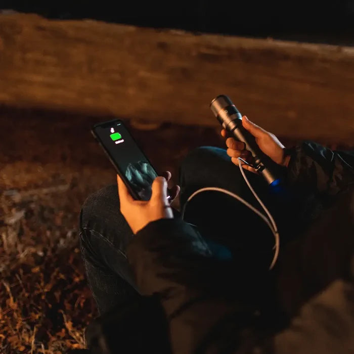 NEBO Davinci 3500 torch being used at night as a power bank to charge a phone