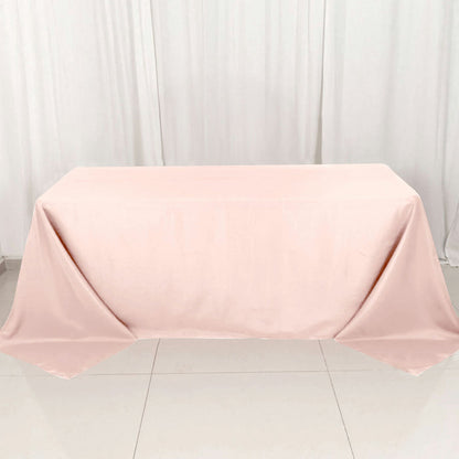 Pink tablecloth draped over a table on a white backdrop