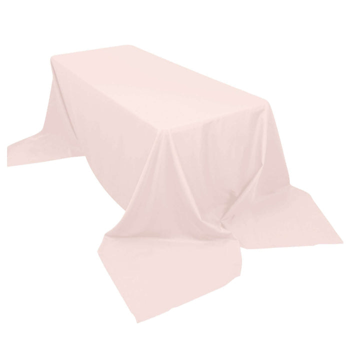 Pink tablecloth draped over a table on a plain background