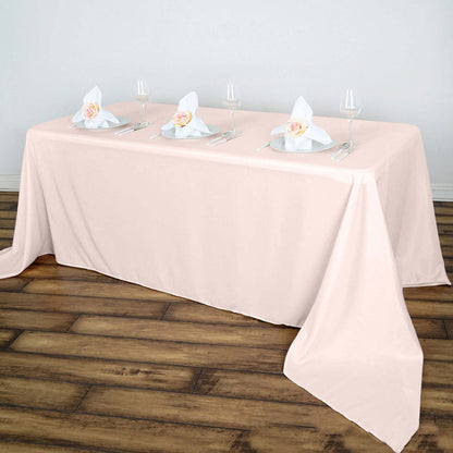 Elegant pink tablecloth with napkins and glasses set for a dining occasion.