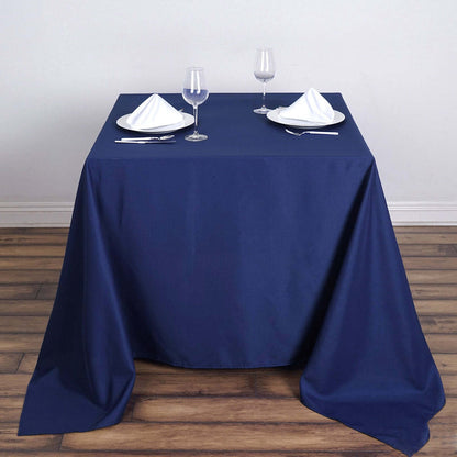 Elegant navy blue tablecloth with white dinnerware and glasses.