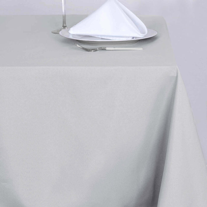 Gray tablecloth draped elegantly on a table with a plate and folded napkin.