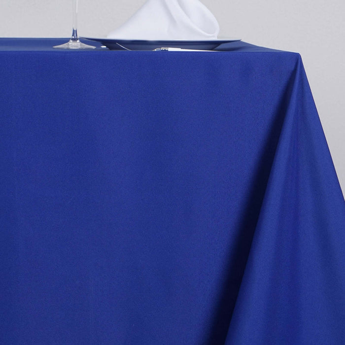 Blue tablecloth draping elegantly over a table with a glass and plate.