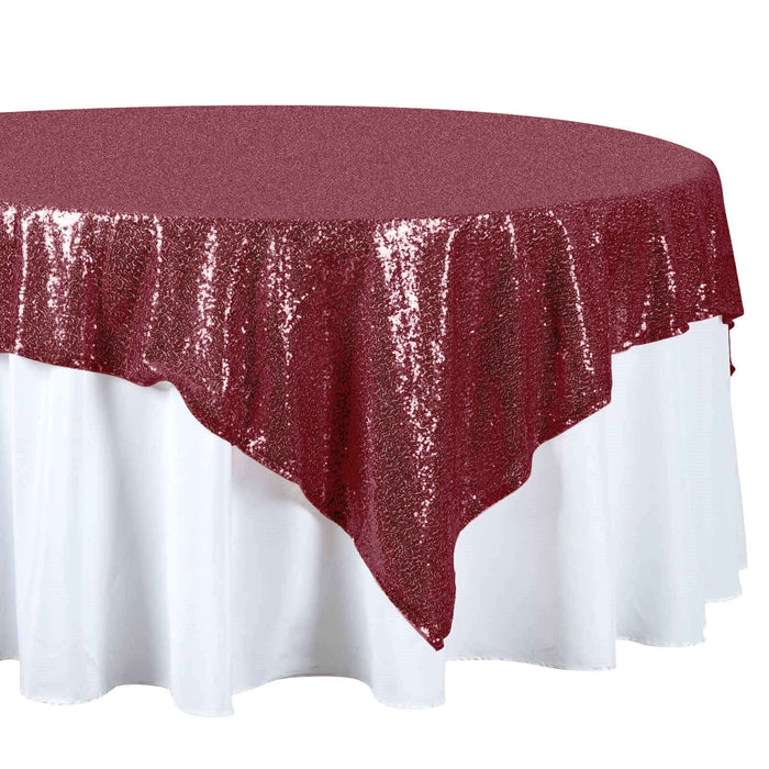 Burgundy sequin tablecloth draped over a white table