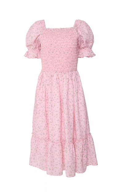 The Ivy City Co Valencia Dress in Pink Ditsy Floral features a knee-length tiered skirt, puffed short sleeves, smocked bodice, and delicate floral print. Its maternity-friendly fit creates a soft, feminine, vintage-inspired look.