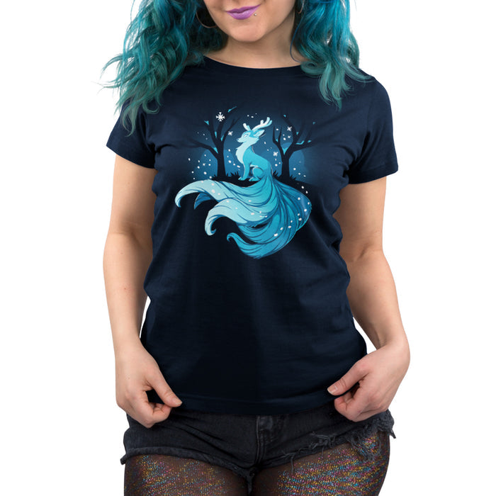 Premium Cotton T-shirt_TeeTurtle navy blue Winter Kitsune featuring a blue, fox-like creature with antlers, long tails, and a flowing mane sitting in a snowy forest with bare trees.