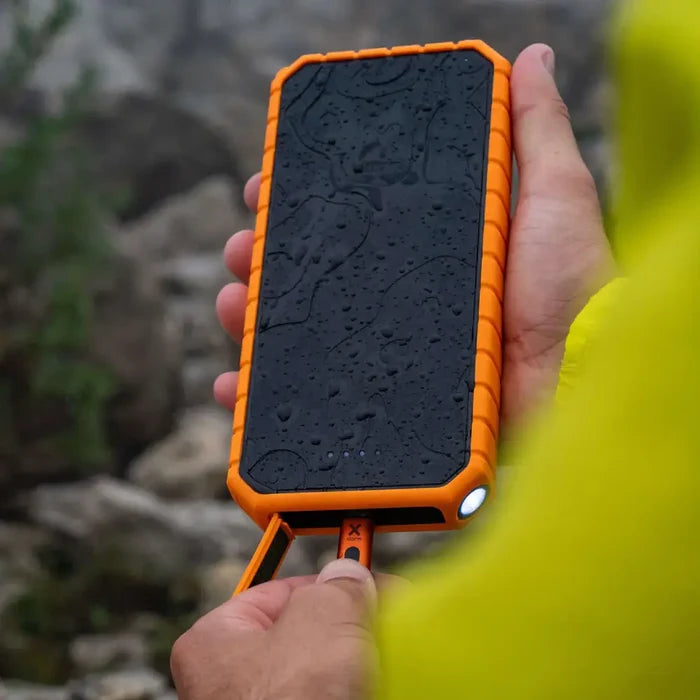 Person outsdie connecting a charging cable to the port of a Xtorm XR202 Rugged Pro Water Resistant Power Bank