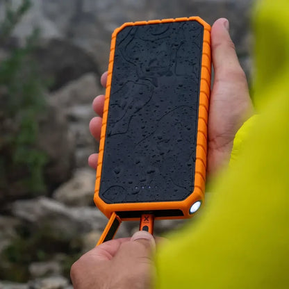 Person outsdie connecting a charging cable to the port of a Xtorm XR202 Rugged Pro Water Resistant Power Bank