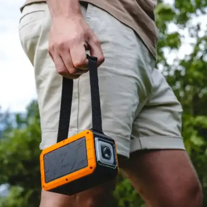 Person holding a Xtorm XR204 Rugged Pro Water Resistant Power Bank Torch by the carry strap whilst walking outside